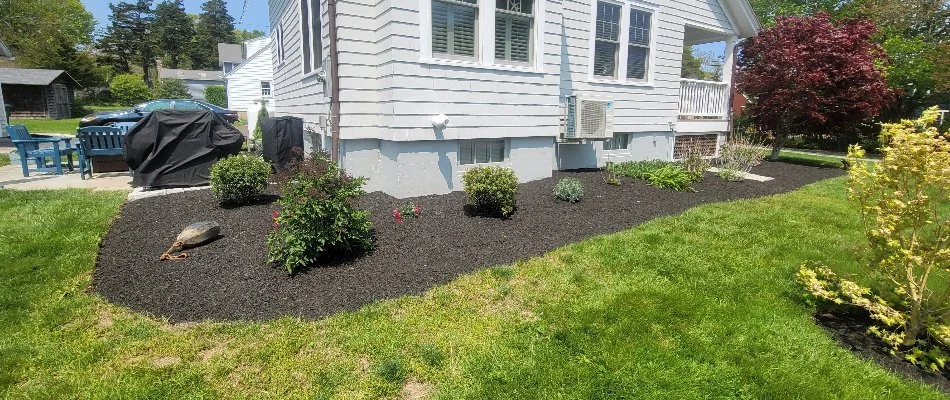 Landscape along a house in Groton, CT, with mulch and plants.