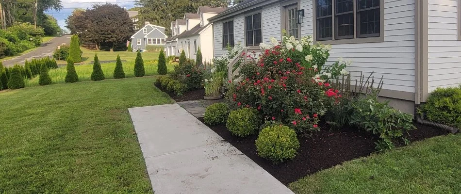 Mulched landscape bed in Groton, CT, with plantings.