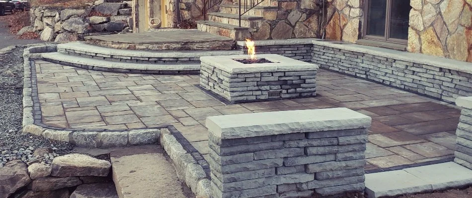 Patio in Gales Ferry, CT, with fire pit and seating wall.