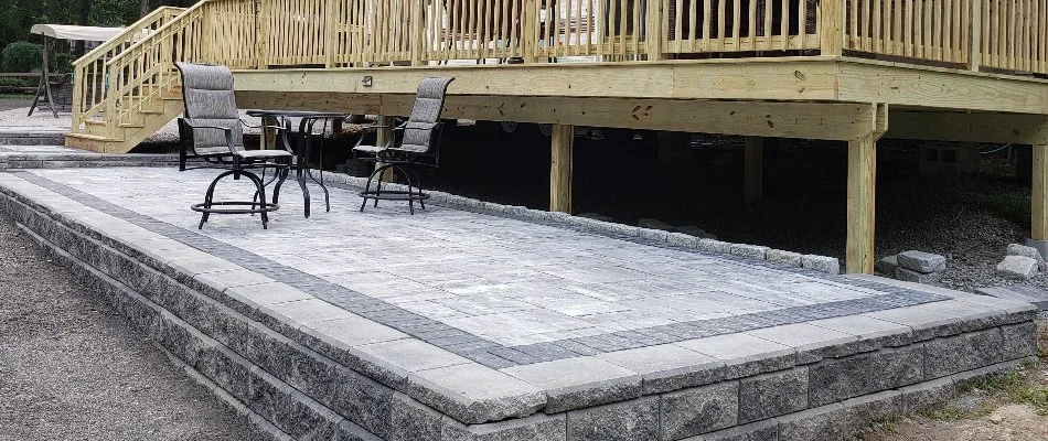 Paver patio beside a wooden deck in Groton, CT.