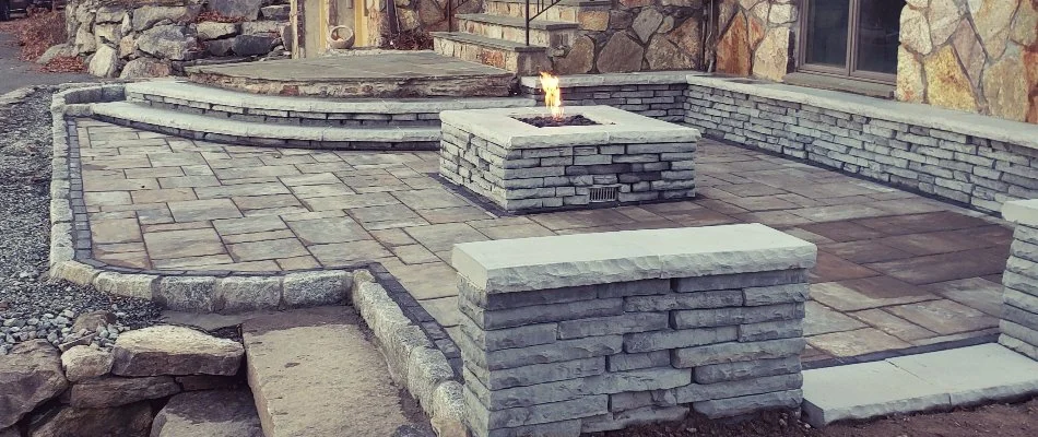 Paver patio in Groton, CT, with a retaining wall and fire pit.