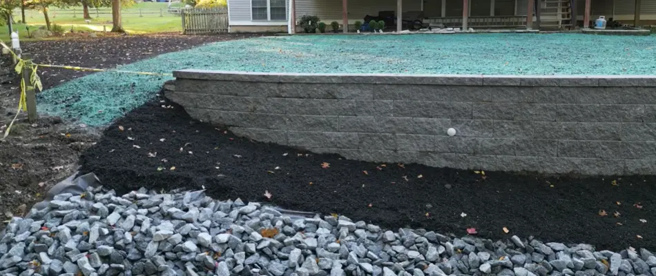 Retaining wall in Mystic, CT, with a teal hydroseeding slurry.