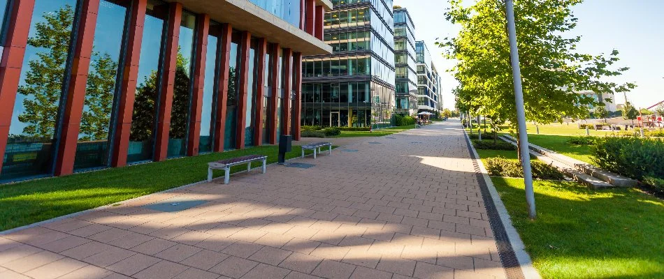 Commercial property in Mystic, CT, with a walkway, lawn, benches, and plants.