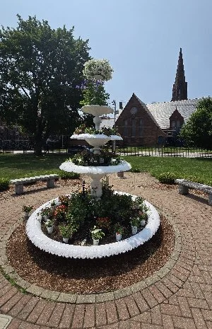 Stonington, CT home with pergola, retaining wall, and stamped concrete patio.
